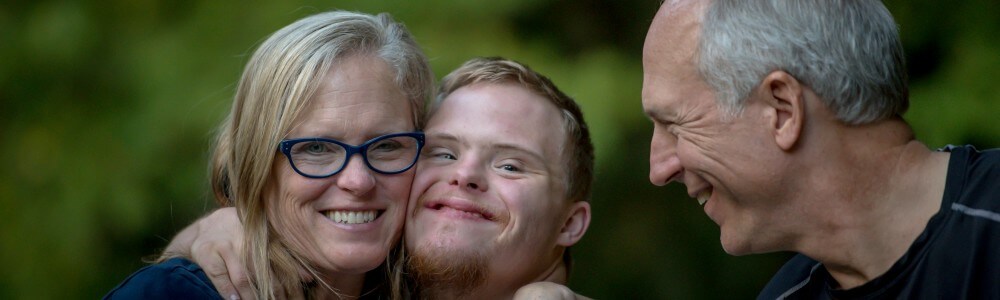 Ein Junge mit Down-Syndrom und seine Eltern